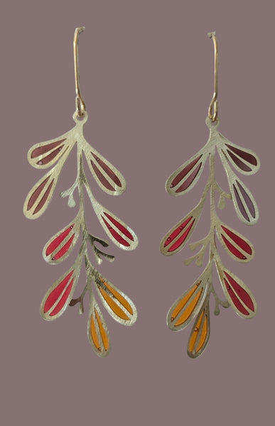 Pair of earrings with leaf-like design on a green background