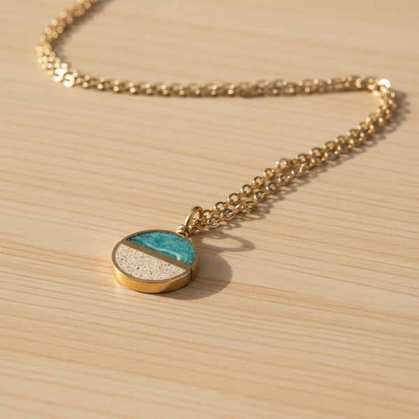Necklace with a round pendant featuring two colors on a beige background