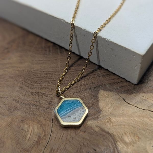 Necklace with a hexagonal pendant on a wooden surface
