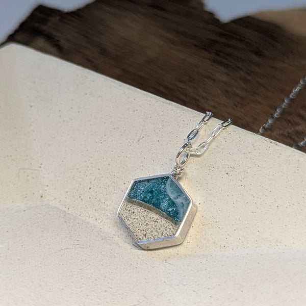Hexagonal pendant necklace on a neutral background